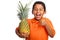 Child Smiling and Holding Pineapple with Thumb Up