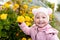 Child sniffs yellow flowers. scent of flowers