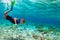 Child in snorkeling mask dive underwater in blue sea lagoon