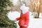 Child in snowy winter near christmas tree