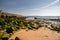 Child on the Socoa beach in France next to some mossy rocks on a sunny day