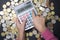 Child with solar powered calculator against scattered coins calculating study funds