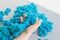 The child sorts the blue kinetic sand with his fingers, develops motor skills of the hands