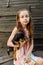 The child spending time with her pet. Little girl with chihuahua dog on the background of a wooden backdrop