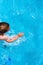 Child splashing in the cool water of a pool in summer