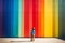 A child standing on front of rainbow colored wall. Child mental health concept. ASD, autism spectrum disorder awareness concept.