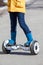 Child standing on groscooter, self-balanced two-wheeled urban mode of transportation, close up view with feet