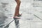 Child standing, jumping, playing in a fountain while hot weather