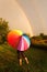 Child Standing in Rain With Colorful Umbrella Looking at Double