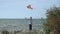 Child stands on the beach and plays with a kite. games for young kid