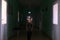 The child stands in the middle of the dark corridor of the hospital. Clinic fear and panic attacks. The boy is afraid of doctors.