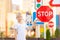 A child stands at a stop sign and points at it with his finger, traffic rules for children