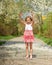 Child stands under cherry tree in spring