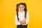 Child starting school. Happy small child keeping arms crossed on yellow background. Little child smiling with long