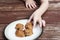 Child stealing a pumpkin chocolate chip cookie from a plate.