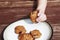 Child stealing a pumpkin chocolate chip cookie from a plate.