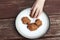 Child stealing a pumpkin chocolate chip cookie from a plate.