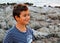 Child in striped t-shirt playing happy by the sea at sunset, portrait