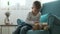 Child stroking a ginger domestic cat, sitting in armchair at home