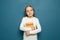 Child student girl with German language book on the background of blue chalkboard