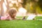 Child studies and learn with tablet outside. Funny School Child Schoolboy lies on grass. Distance learning. A pupil boy