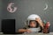 child studies remotely at school, wearing an astronaut`s helmet. back to school