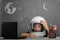 child studies remotely at school, wearing an astronaut`s helmet. back to school