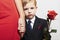Child in suit with mother. flower. red dress. family. fashionable little boy. red rose. take the hand
