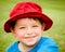 Child in summer portrait wearing bright red hat