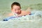 Child surfing on bodyboard at beach