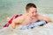 Child surfing on bodyboard at beach