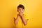 Child surprised wants to speak. Amazed and wondered expression. Yellow background