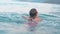 Child swimming and diving into sea water during summer holidays