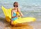 Child swimming on inflatable beach mattress.