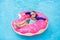 Child in swimming pool on donut float