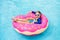 Child in swimming pool on donut float