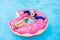 Child in swimming pool on donut float