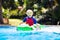 Child in swimming pool. Kid on inflatable float