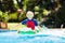 Child in swimming pool. Kid on inflatable float