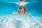 Child swimming underwater with thumbs up. Underwater kid swim under water. Child boy swimming and diving underwater in