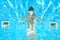 Child swims in pool underwater, girl has fun in water