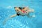 Child swims in pool underwater, happy active girl dives and has fun under water, kid sport