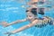Child swims in pool underwater, happy girl dives and has fun under water, kid fitness and sport on family vacation