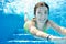 Child swims in swimming pool underwater, happy active teenager girl dives and has fun under water, kid fitness and sport