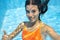 Child swims in swimming pool underwater, happy active teenager girl dives and has fun under water, kid fitness and sport