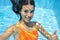 Child swims in swimming pool underwater, happy active teenager girl dives and has fun under water, kid fitness and sport