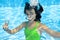 Child swims in swimming pool underwater, happy active teenager girl dives and has fun under water, kid fitness and sport
