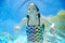 Child swims underwater in swimming pool, happy active teenager girl dives and has fun under water, kid fitness and sport
