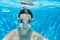 Child swims underwater in swimming pool, happy active teenager girl dives and has fun under water, kid fitness and sport