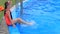 A child in a swimsuit and a water mask swims in the pool of the water park.